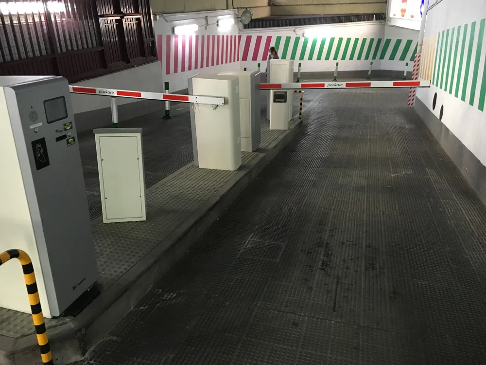 Control de acceso con barreras y módulos de pago de estacionamiento